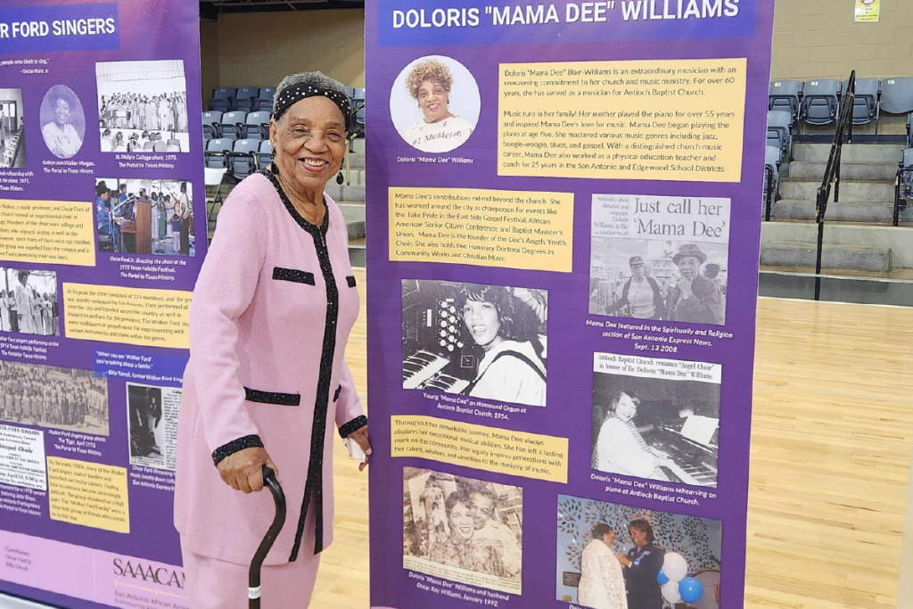 With more than 70 years in music ministry, the legendary “Mama Dee” stands beside the exhibit panel honoring her legacy.